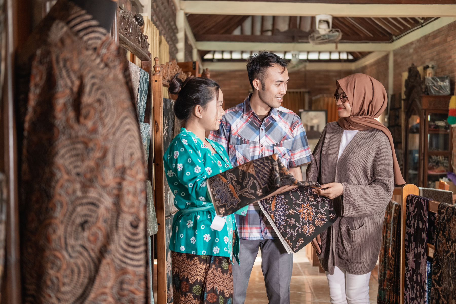 Woman Showing the Traditional Batik Cloth She Sells to Customer